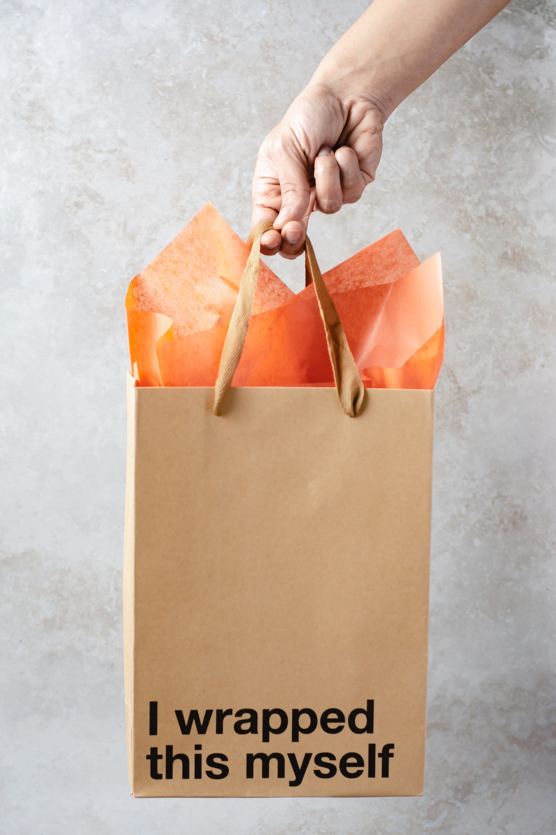 Kraft gift bag with brown ribbon handle, perfect for adult gifts.