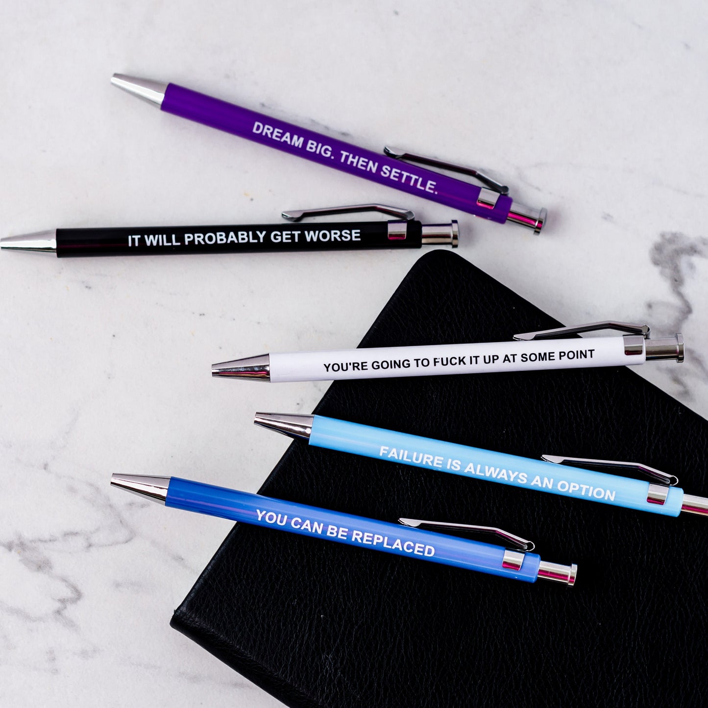 Set of demotivational pens with sarcastic phrases, perfect for dark humor lovers.