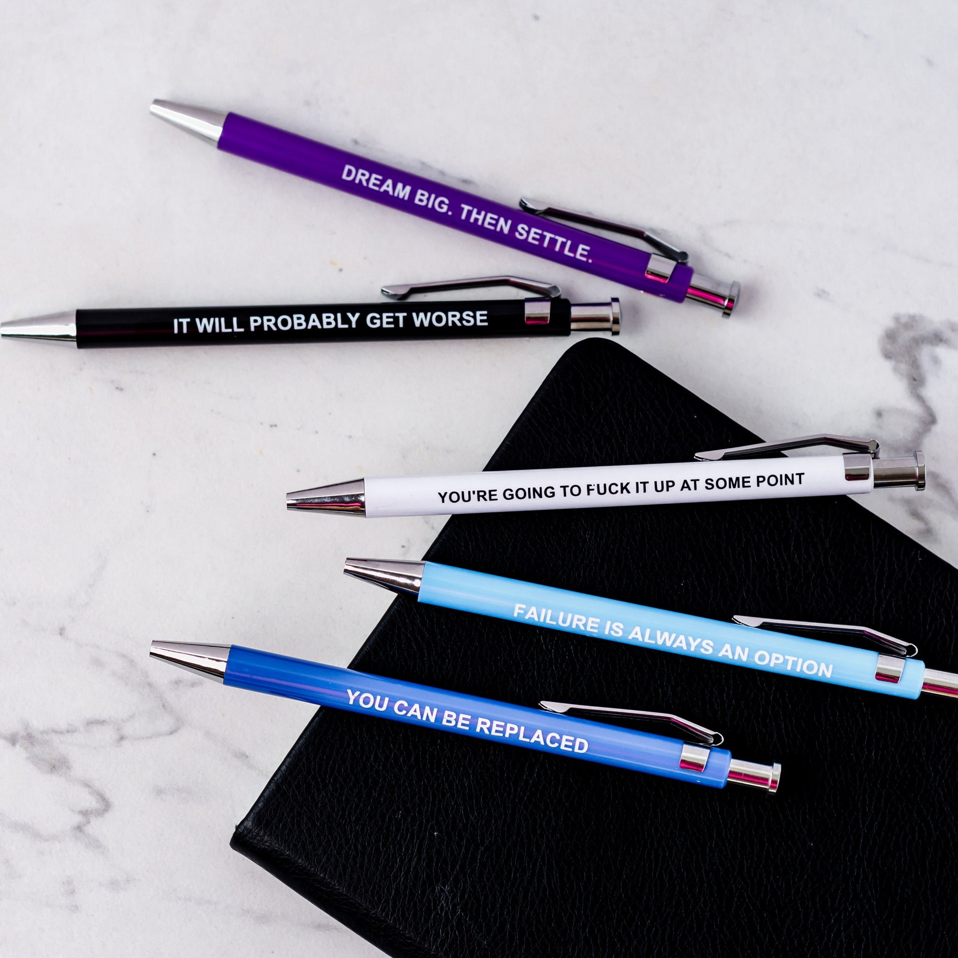 Set of demotivational pens with sarcastic phrases, perfect for dark humor lovers.